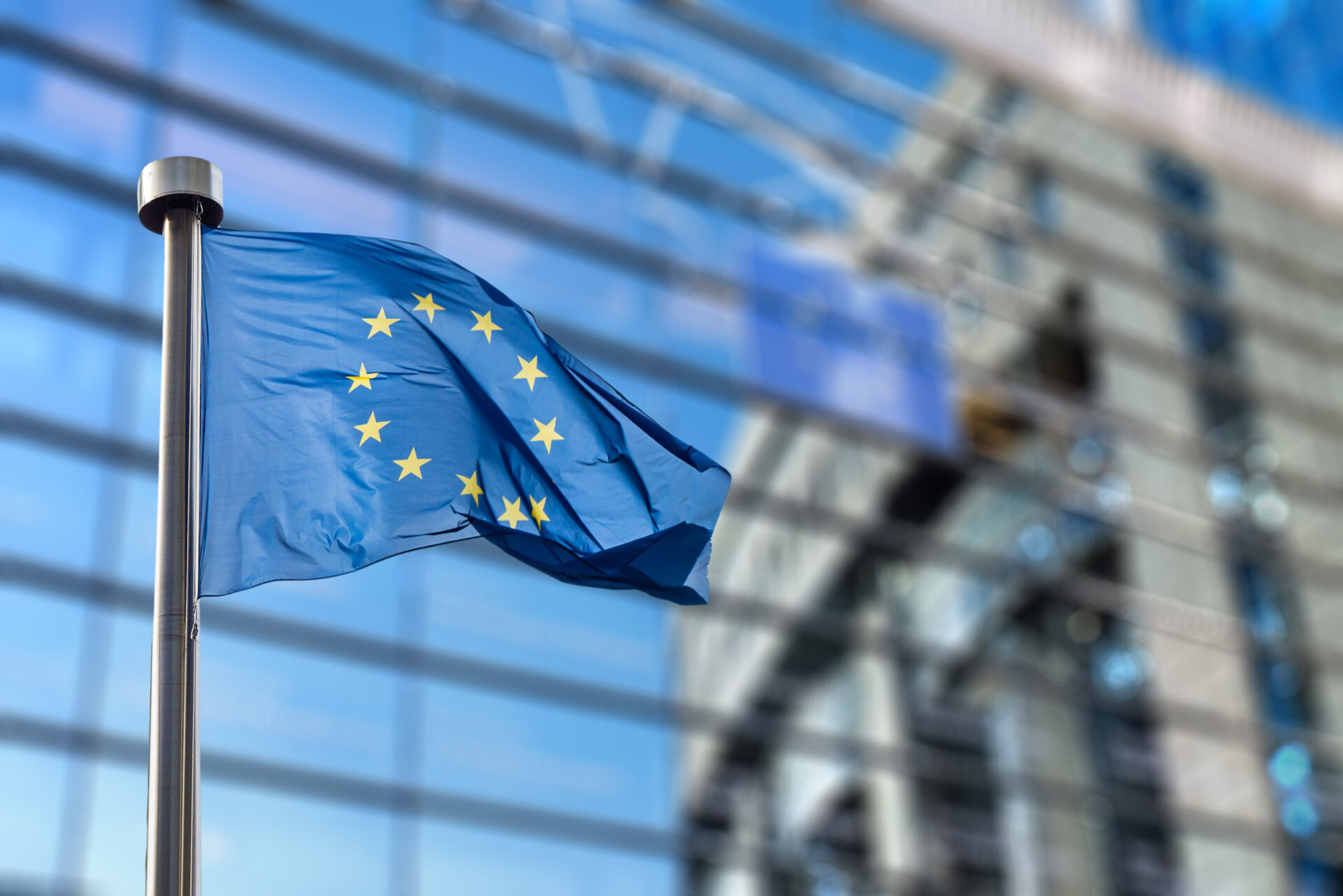 European Union flags in front of the blurred European Parliament in Brussels, Belgium